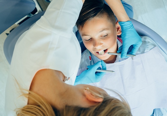 Child receiving dental checkup and teeth cleaning