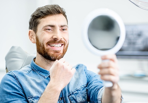 Man looking at smile after cosmetic dentistry