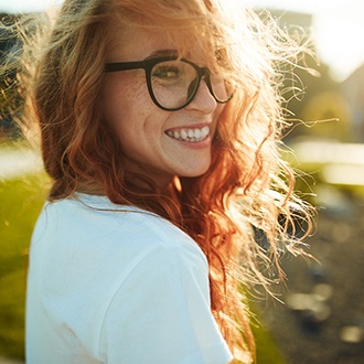 a woman smiling happily with dentures in Zionsville