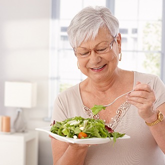 a woman eating healthy with dentures in Zionsville