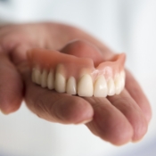 Hand holding a full denture