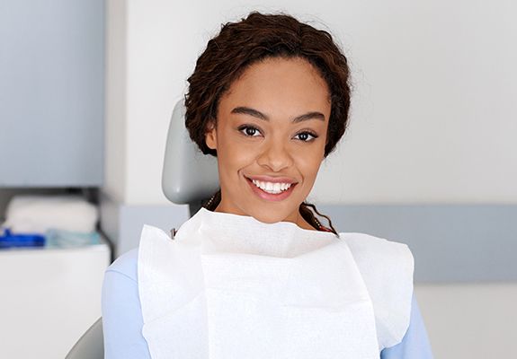Woman smiling during her first preventive dentistry visit