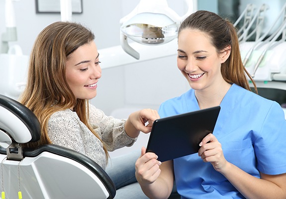 Woman talking to dental team member during dental checkups and teeth cleanings