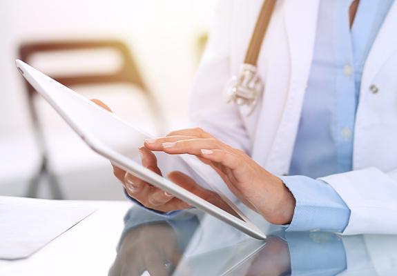 Dentist using tablet computer to review patient file