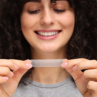 Woman holding a whitening strip