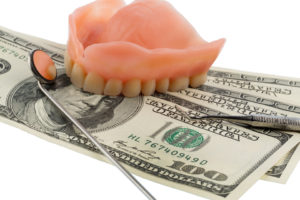 $100 bills under denture and dental tools