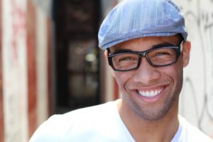 man wearing glasses and hat smiling