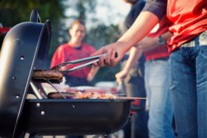 woman grilling burgers red shirt