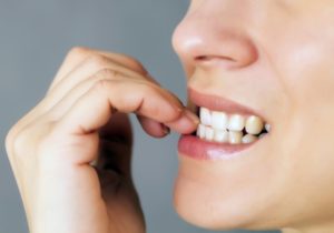 Woman biting her nails.