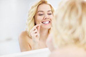 A woman flossing her teeth 