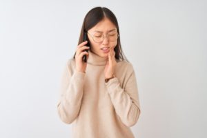 person with a toothache on the phone