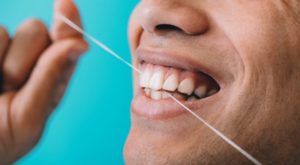 closeup of a person flossing their teeth