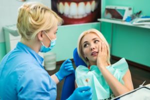 Pained woman talking to her Zionsville emergency dentist