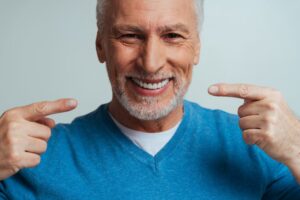 Man smiling after getting rid of his denture sores