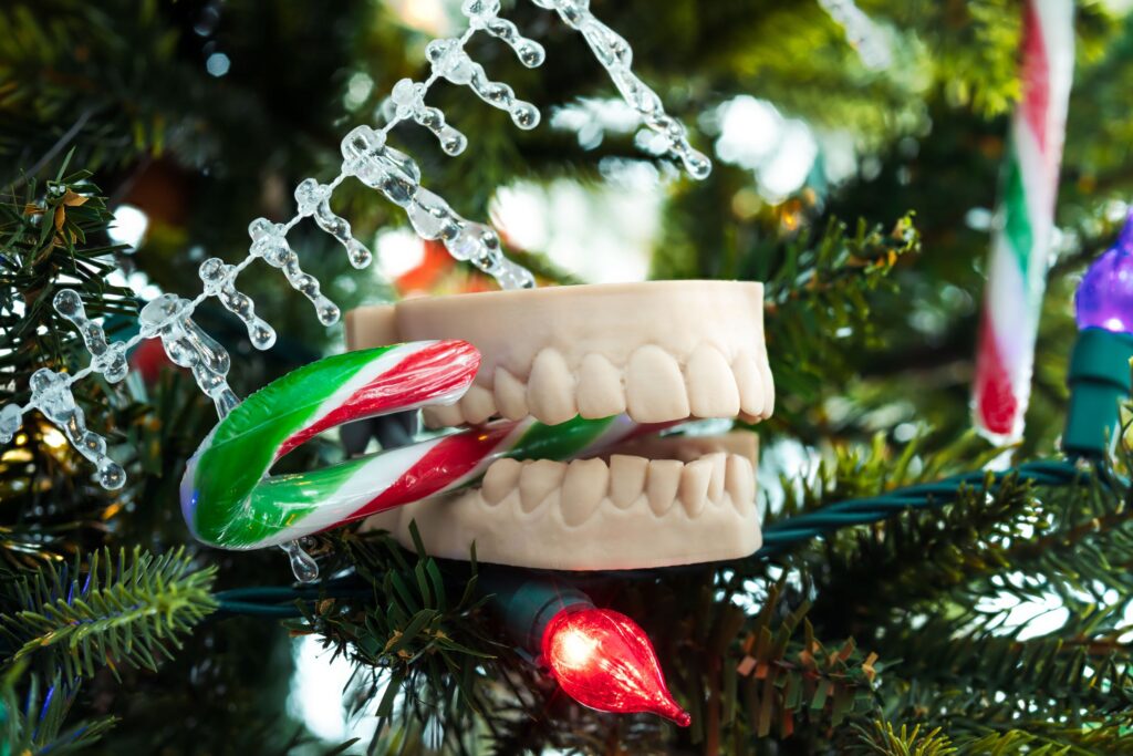 Model teeth in yule tree biting candy cane